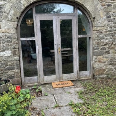 Stone arch entrance to The Coach House holiday cottage in West Wales with private patio doors.